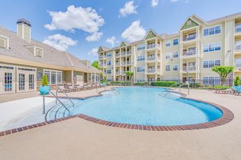 a swimming pool with an apartment building in the background